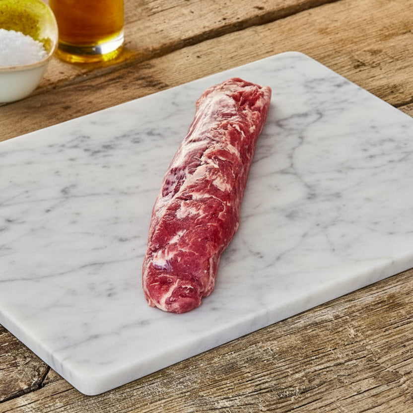 Raw Iberico pork tenderloin on a marble chopping board